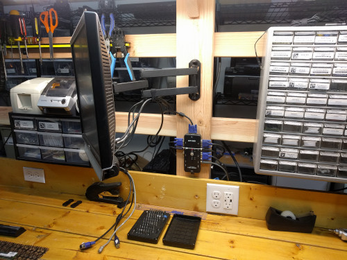 The middle monitor is connected to the workbench computer as well as two sets of VGA and USB cables.  The keyboard and mouse go through the KVM switch.